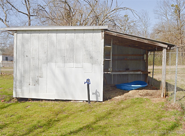 view of outbuilding featuring fence and an outbuilding