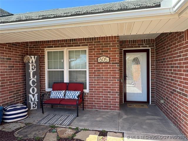 doorway to property with brick siding