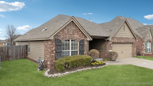 view of front of property with brick siding, concrete driveway, a front yard, fence, and a garage