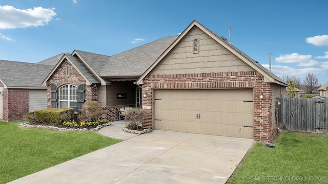 view of front of house with a front yard, fence, driveway, a garage, and brick siding