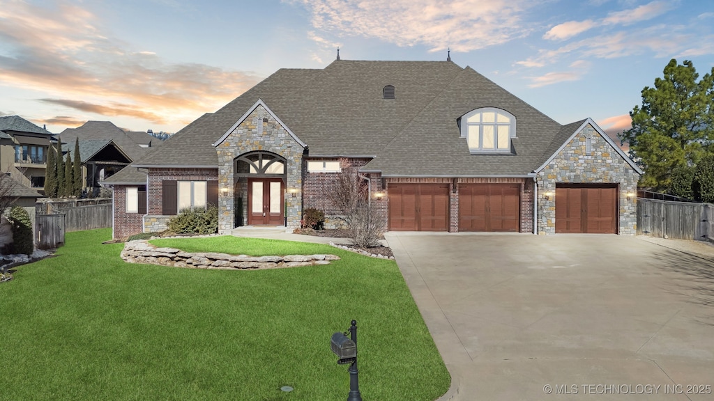 10708 S Gum St, Jenks, OK 74037 - french provincial home featuring stone siding, a shingled roof, driveway, a garage, and brick siding