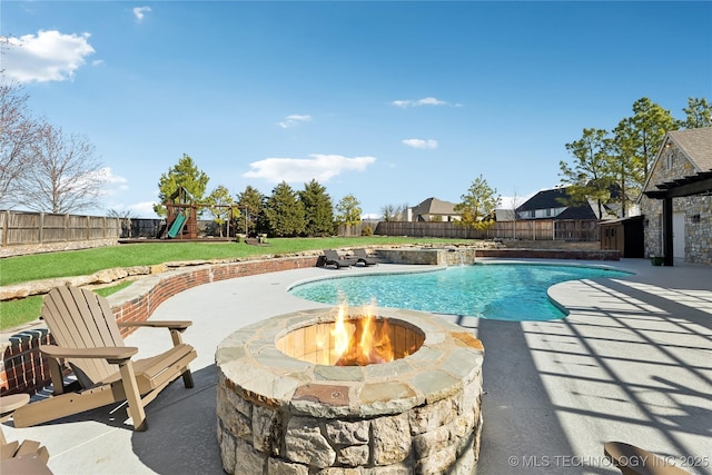 view of swimming pool with an outdoor fire pit, a fenced in pool, a patio, a fenced backyard, and a playground