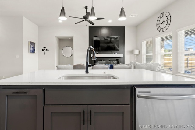 kitchen with hanging light fixtures, open floor plan, a sink, ceiling fan, and dishwasher