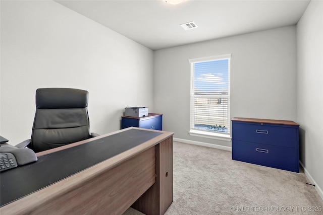 office featuring baseboards, visible vents, and light colored carpet