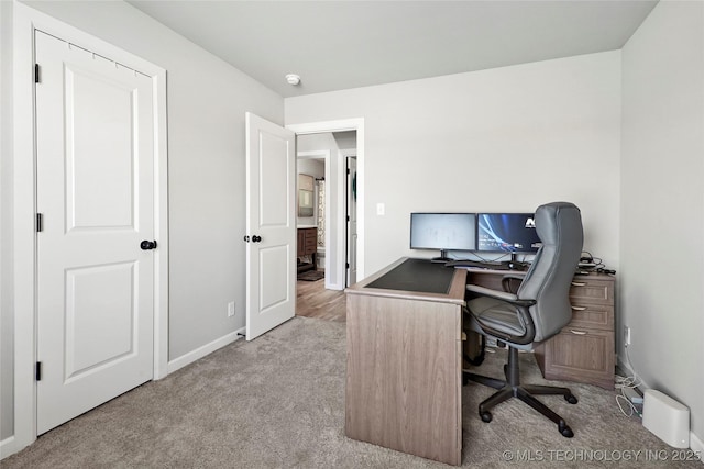 carpeted office featuring baseboards