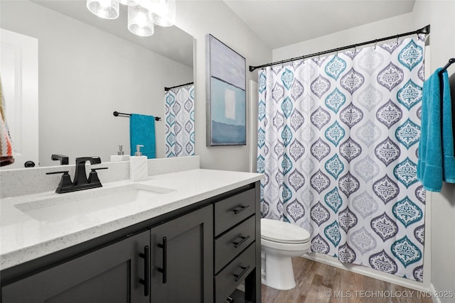 full bathroom with toilet, a shower with curtain, wood finished floors, and vanity