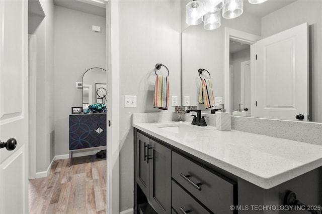 bathroom with vanity, baseboards, and wood finished floors