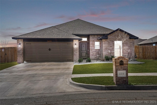 view of front facade featuring a yard, brick siding, driveway, and fence