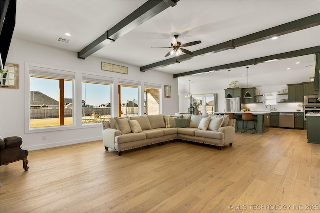 living room featuring ceiling fan, light wood-style floors, recessed lighting, beamed ceiling, and visible vents