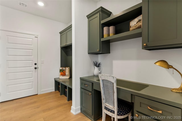 interior space featuring light wood-type flooring, visible vents, baseboards, and built in study area