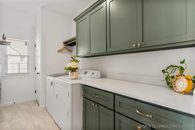 washroom featuring cabinet space, washer and clothes dryer, and baseboards