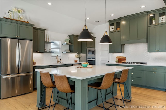 kitchen with a sink, stainless steel appliances, light wood-type flooring, and light countertops