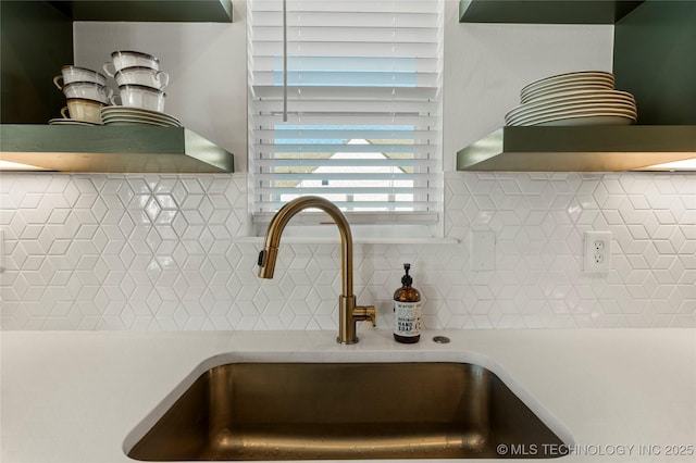 details with open shelves, tasteful backsplash, a sink, and light countertops