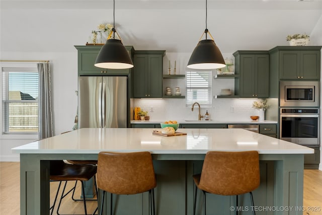 kitchen featuring tasteful backsplash, green cabinetry, stainless steel appliances, open shelves, and a sink