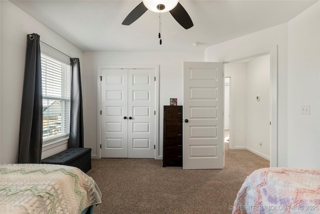 carpeted bedroom featuring a closet, a ceiling fan, and baseboards