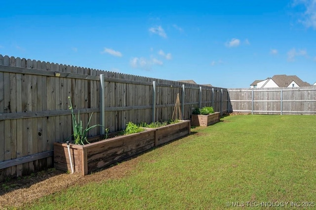 view of yard featuring a fenced backyard and a garden
