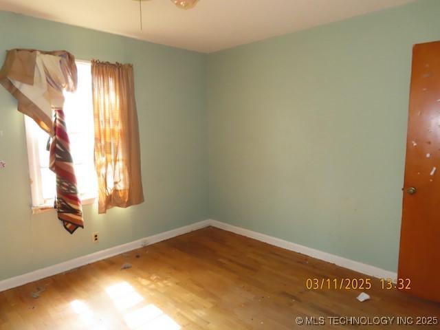 empty room with baseboards and wood finished floors