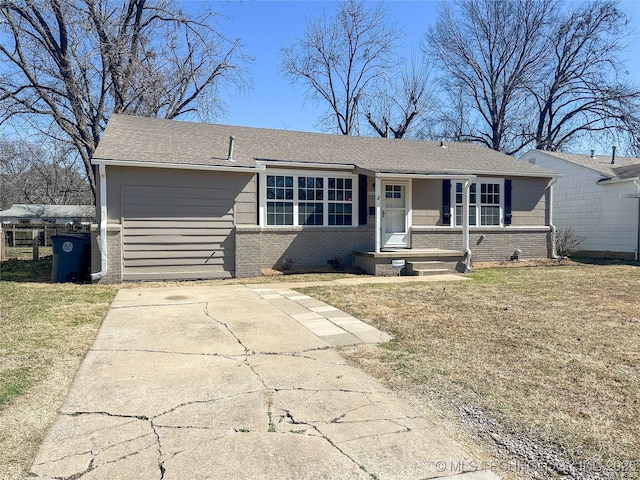 ranch-style home featuring a front yard, brick siding, and driveway