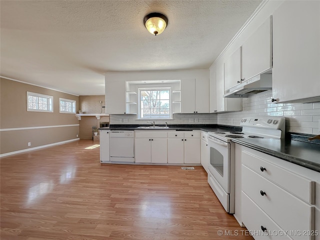 kitchen featuring white appliances, dark countertops, under cabinet range hood, open shelves, and a sink