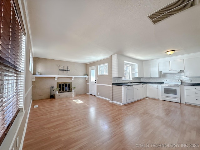 kitchen with dark countertops, visible vents, open floor plan, white appliances, and under cabinet range hood