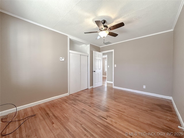 spare room featuring visible vents, ornamental molding, a textured ceiling, and light wood-style flooring