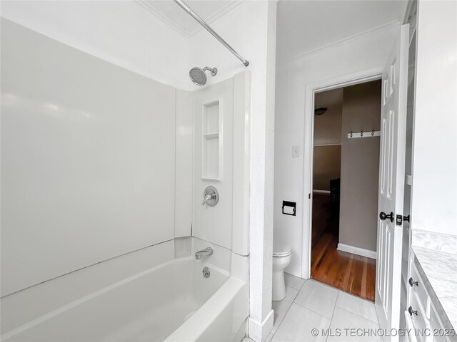 bathroom featuring baseboards, tub / shower combination, toilet, and tile patterned floors