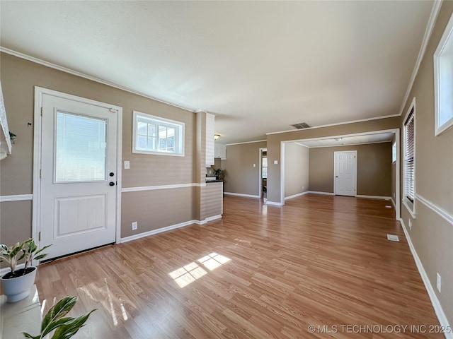 foyer featuring ornamental molding, light wood-type flooring, visible vents, and baseboards