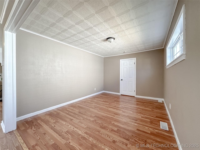 spare room featuring visible vents, an ornate ceiling, and crown molding