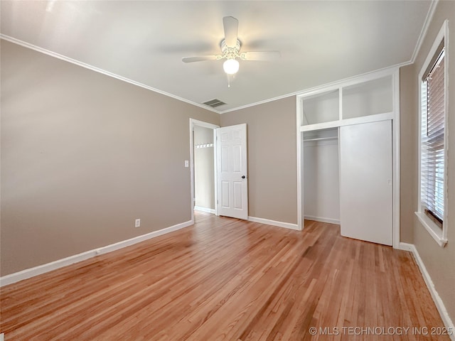 unfurnished bedroom featuring crown molding, a closet, visible vents, light wood-style flooring, and baseboards