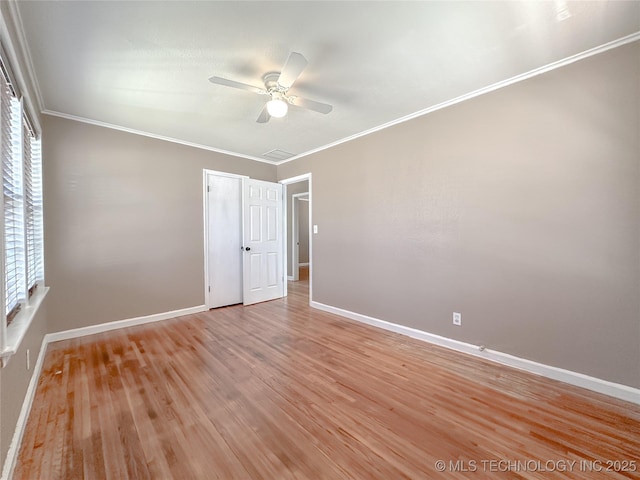 unfurnished bedroom with light wood-style flooring, baseboards, and crown molding