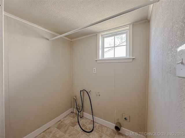 clothes washing area featuring a textured ceiling, laundry area, and baseboards