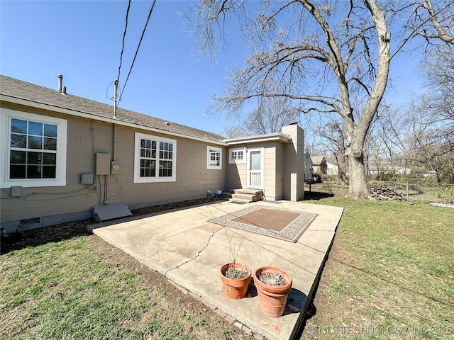 back of property with a yard, a chimney, entry steps, crawl space, and a patio area