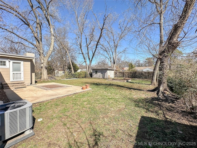 view of yard featuring entry steps, central AC, an outdoor structure, fence, and a patio area