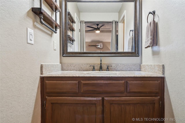 bathroom featuring a textured wall and vanity