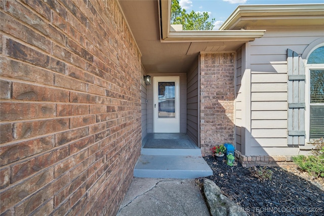 entrance to property featuring brick siding