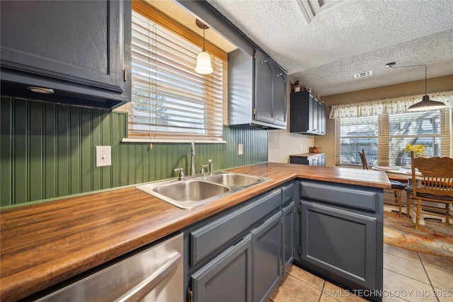 kitchen with a sink, visible vents, wooden counters, and dishwasher