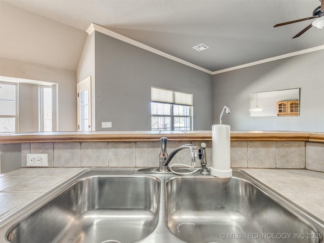 details featuring visible vents, a sink, tile counters, and crown molding