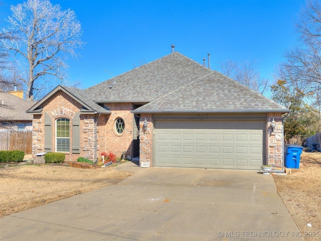 view of front of home featuring brick siding, a shingled roof, concrete driveway, fence, and a garage