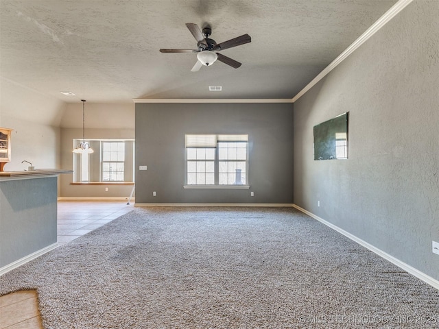 spare room featuring a textured wall, carpet, crown molding, a textured ceiling, and ceiling fan with notable chandelier