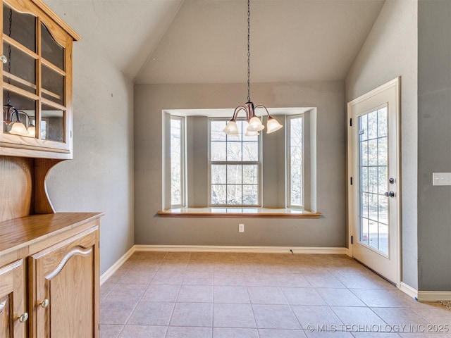 unfurnished dining area with lofted ceiling, a healthy amount of sunlight, an inviting chandelier, and light tile patterned flooring