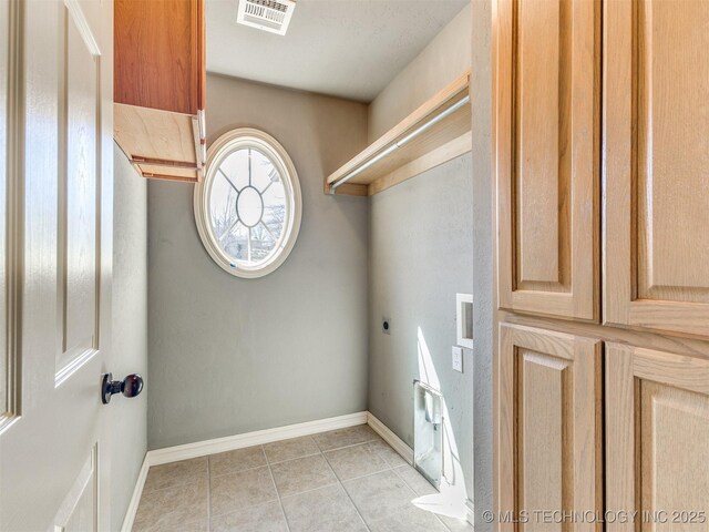 clothes washing area with laundry area, light tile patterned floors, baseboards, visible vents, and hookup for an electric dryer