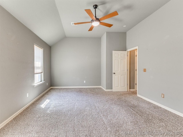 carpeted empty room with ceiling fan, visible vents, baseboards, and vaulted ceiling