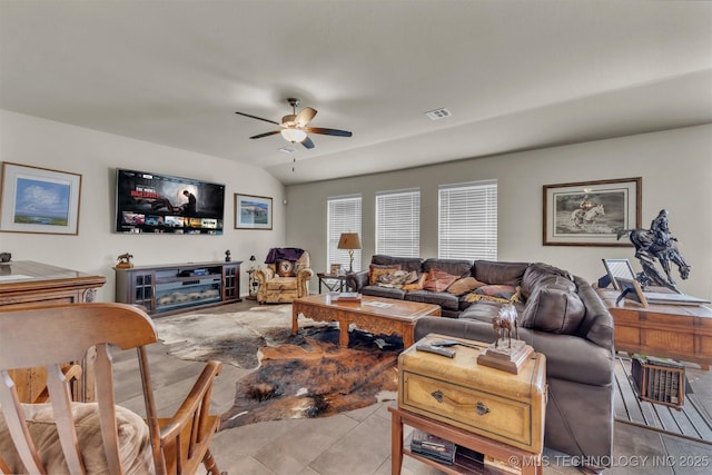 living area featuring a ceiling fan, visible vents, and vaulted ceiling