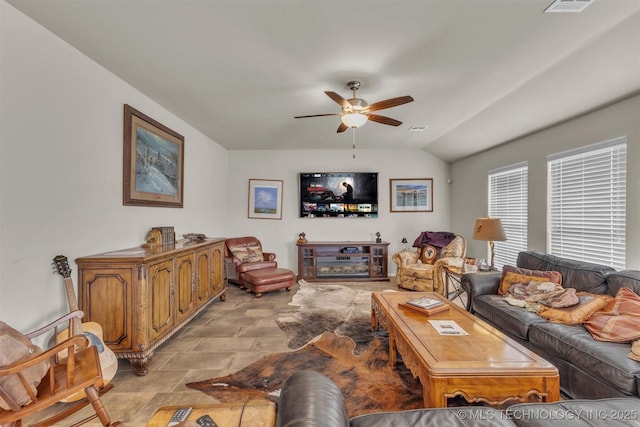 living room with visible vents, stone finish floor, lofted ceiling, and a ceiling fan