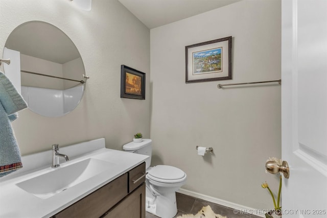 bathroom featuring baseboards, vanity, toilet, and tile patterned floors