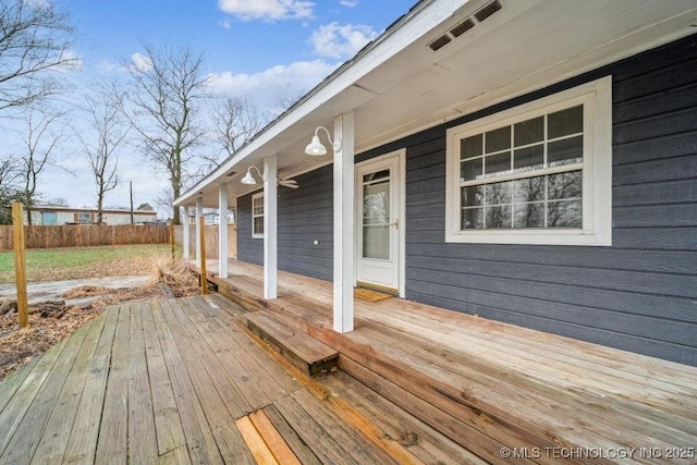 wooden deck featuring a porch and fence