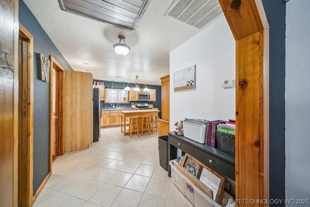 interior space with stainless steel appliances, light countertops, visible vents, and light tile patterned floors