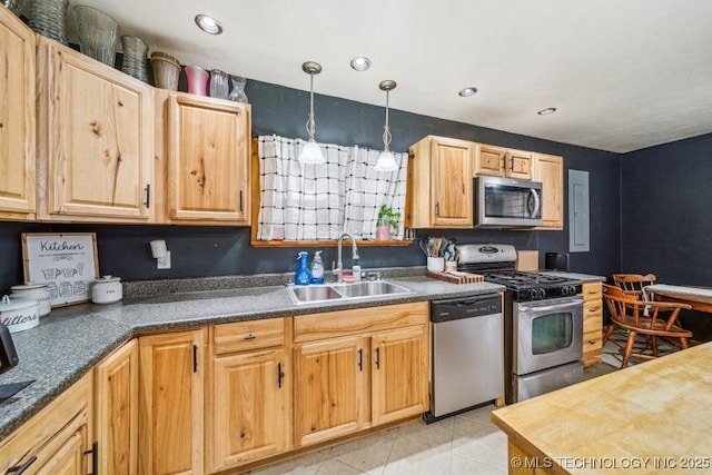 kitchen with light tile patterned floors, dark countertops, hanging light fixtures, stainless steel appliances, and a sink