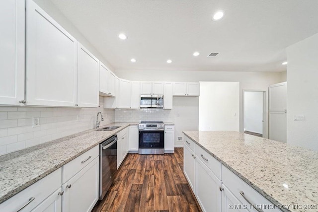 kitchen featuring white cabinets, a sink, visible vents, stainless steel appliances, and backsplash