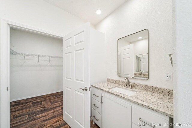 bathroom with vanity, recessed lighting, and wood finished floors